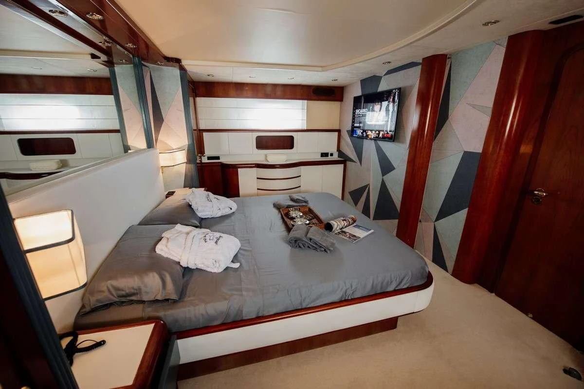 a bed with a white sheet on it aboard BEYOND Yacht for Charter