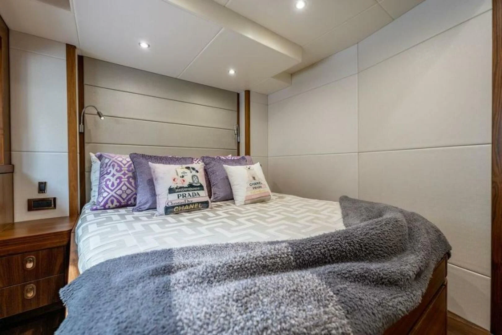 a bed with a pillow and a book on it aboard RAPALLO V Yacht for Sale
