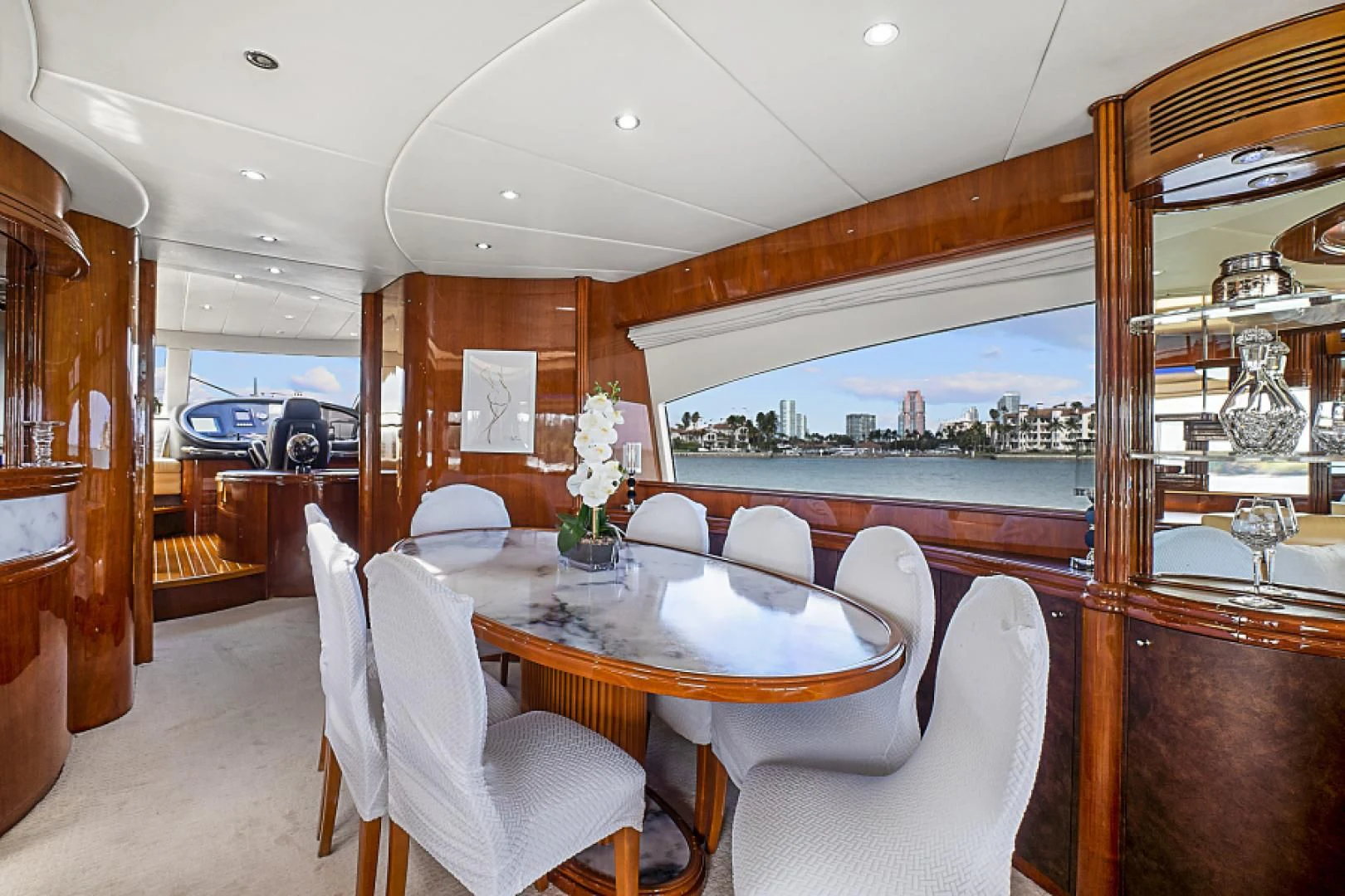 a dining table and chairs in a room with a view of the city aboard EL FARAON Yacht for Sale