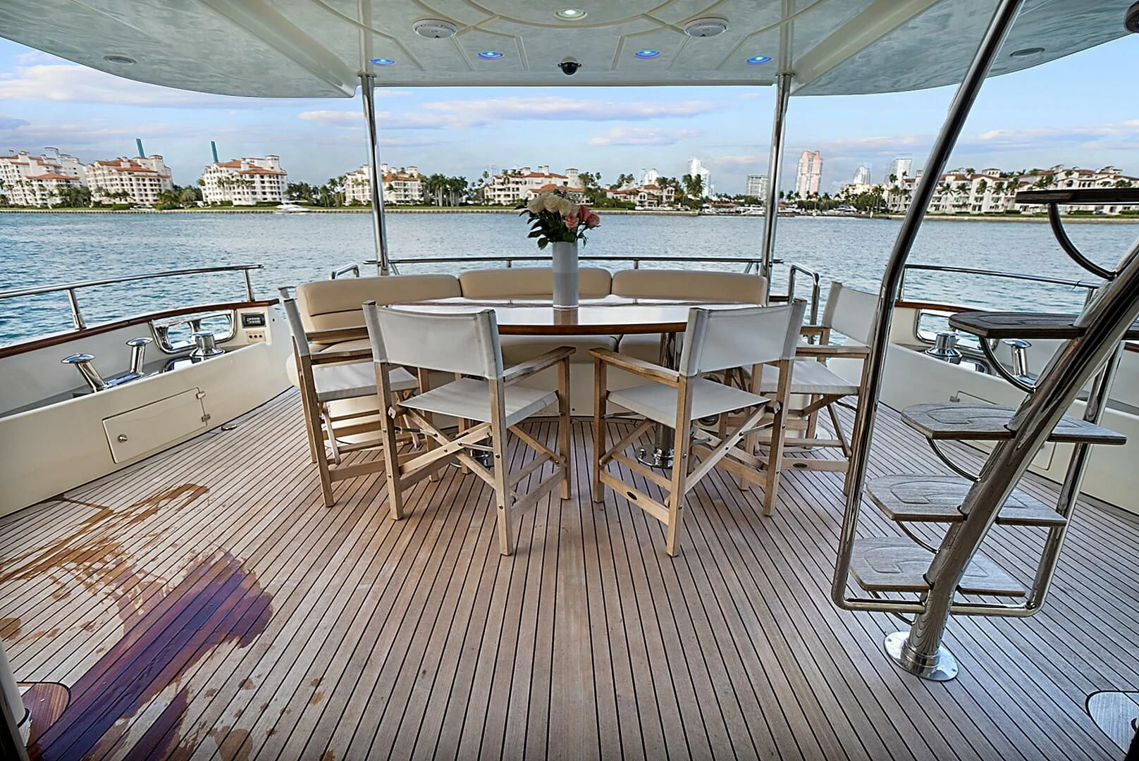 a table and chairs on a deck overlooking a body of water aboard EL FARAON Yacht for Sale