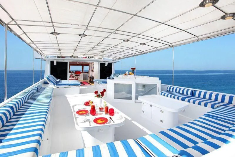 a boat with a table and chairs aboard THE ADMIRAL Yacht for Sale