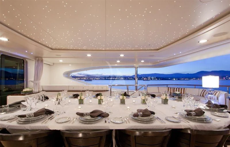 a large room with a table set for a dinner aboard LADY B Yacht for Charter