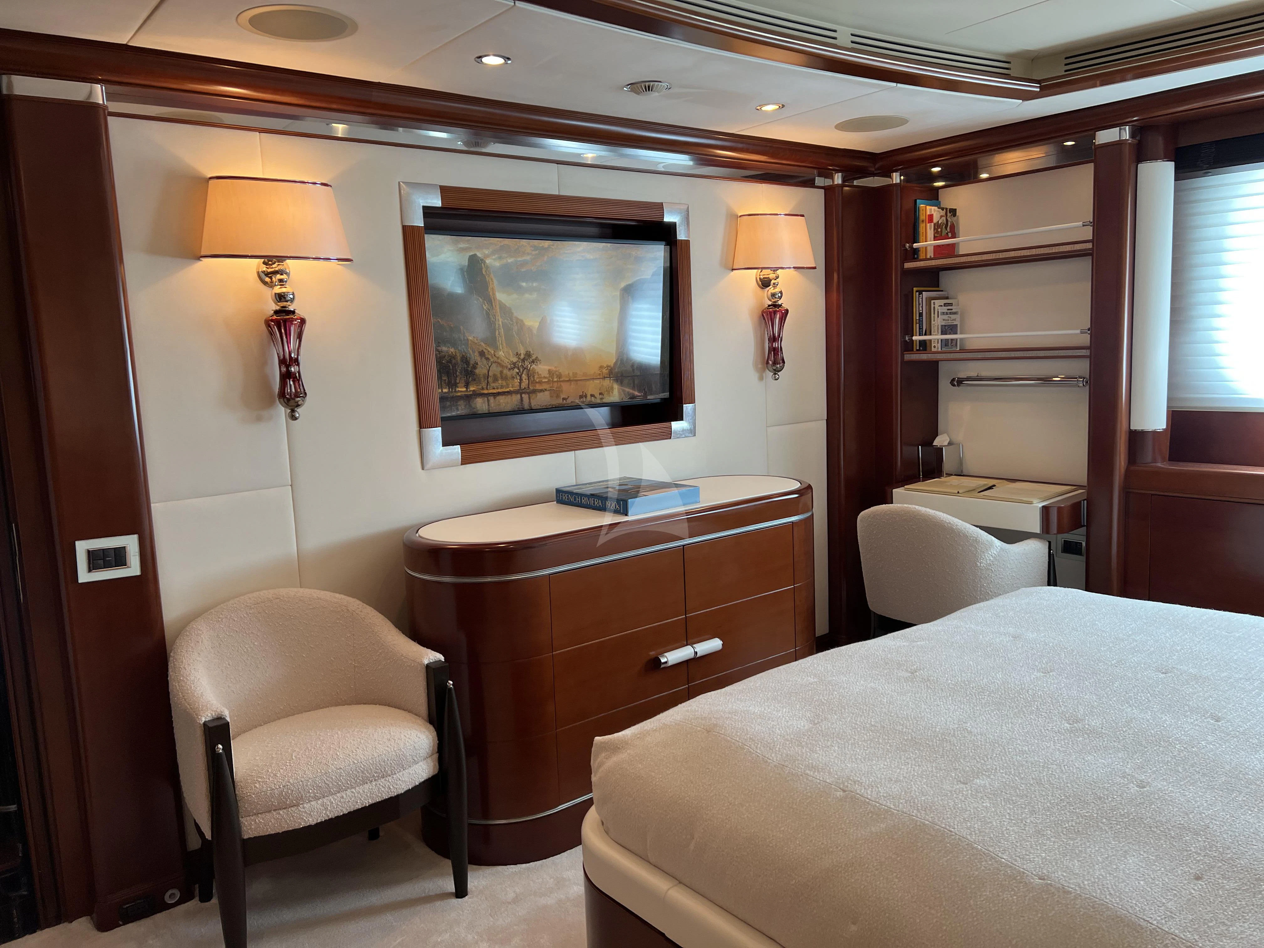 a bedroom with a bed and a television aboard LADY B Yacht for Charter
