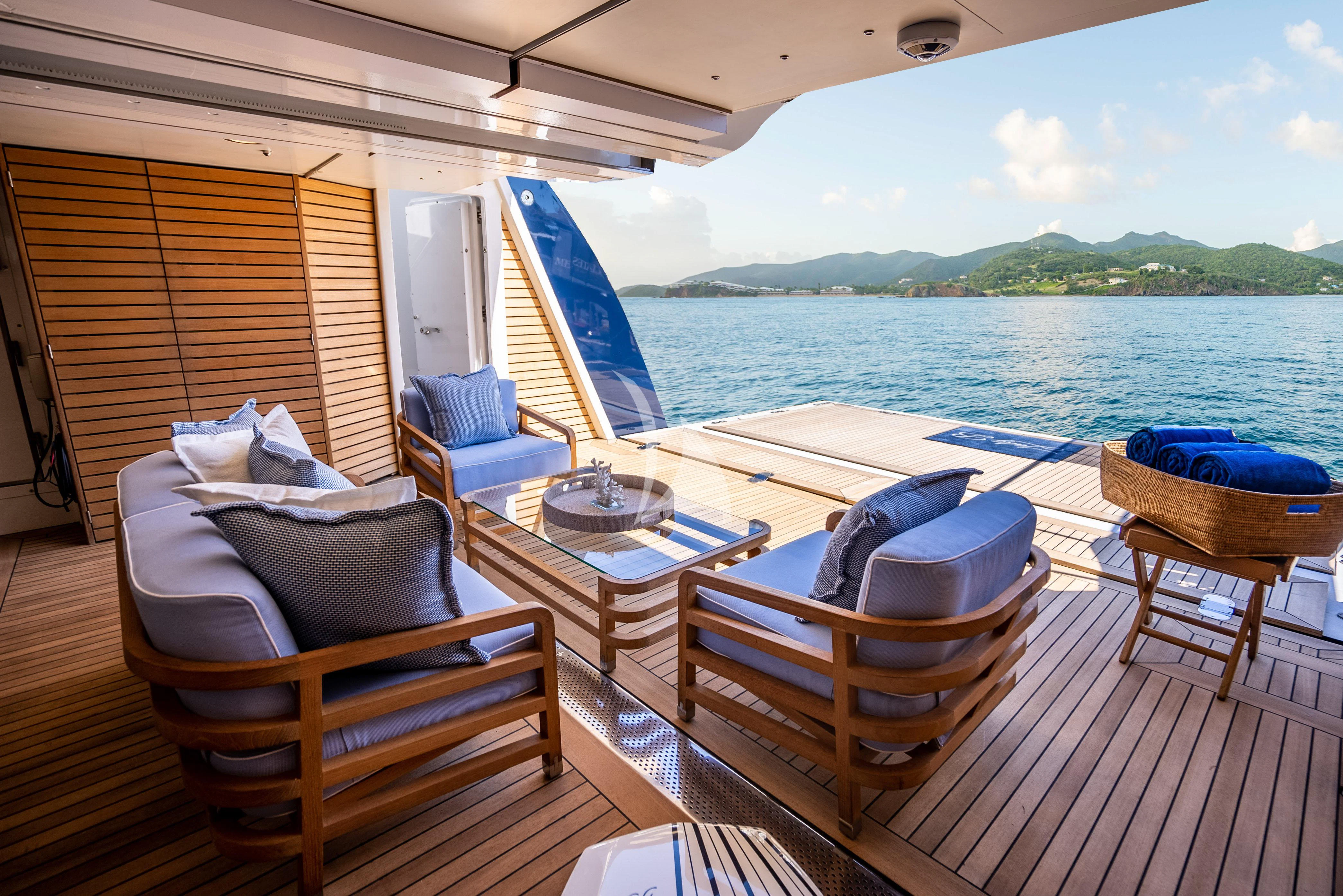 a deck with a table chairs and a view of the water aboard LADY B Yacht for Charter
