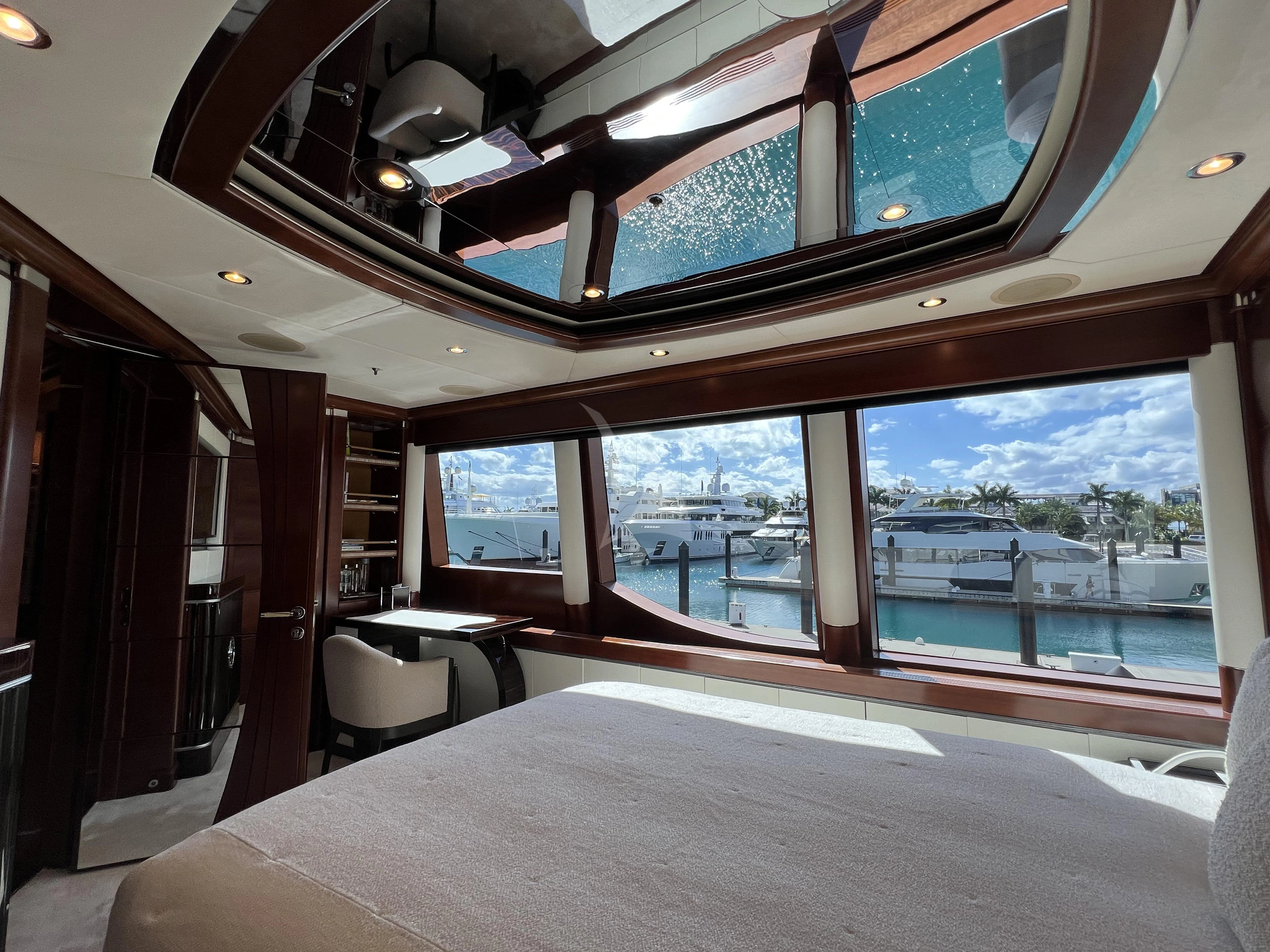 a room with a large window and a table with chairs and a view of the water aboard LADY B Yacht for Charter