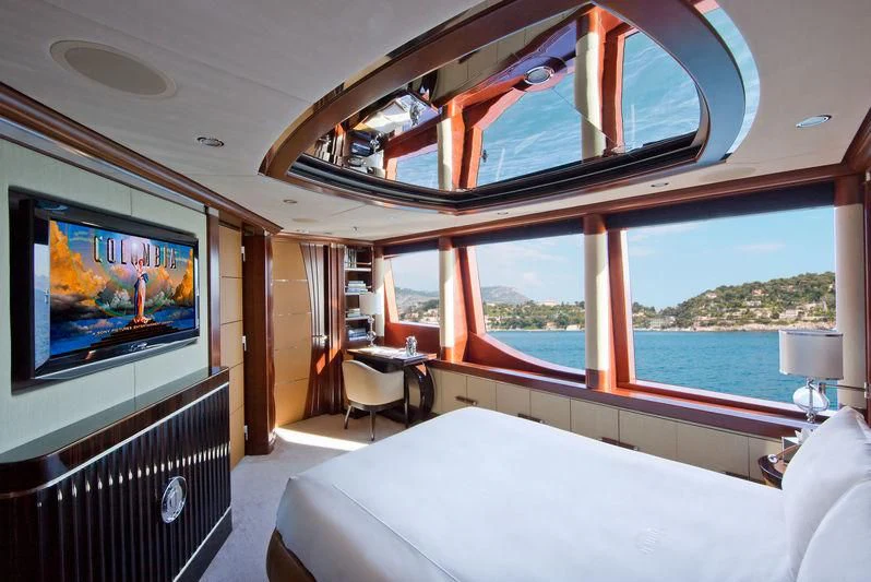 a room with a bed and a tv on the wall aboard LADY B Yacht for Charter