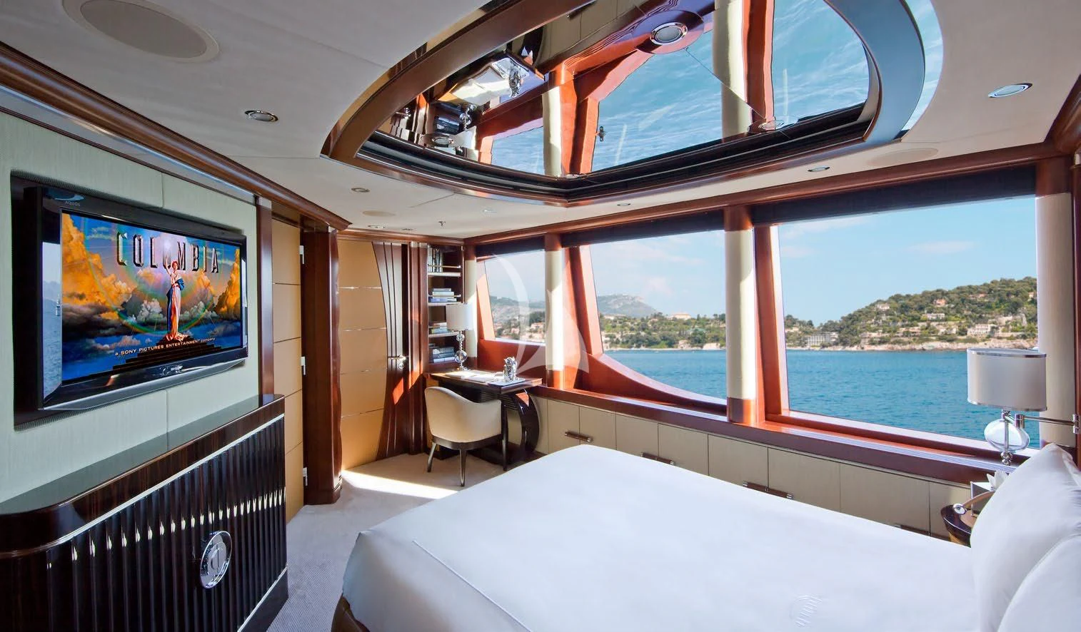 a room with a bed and a television aboard LADY B Yacht for Charter