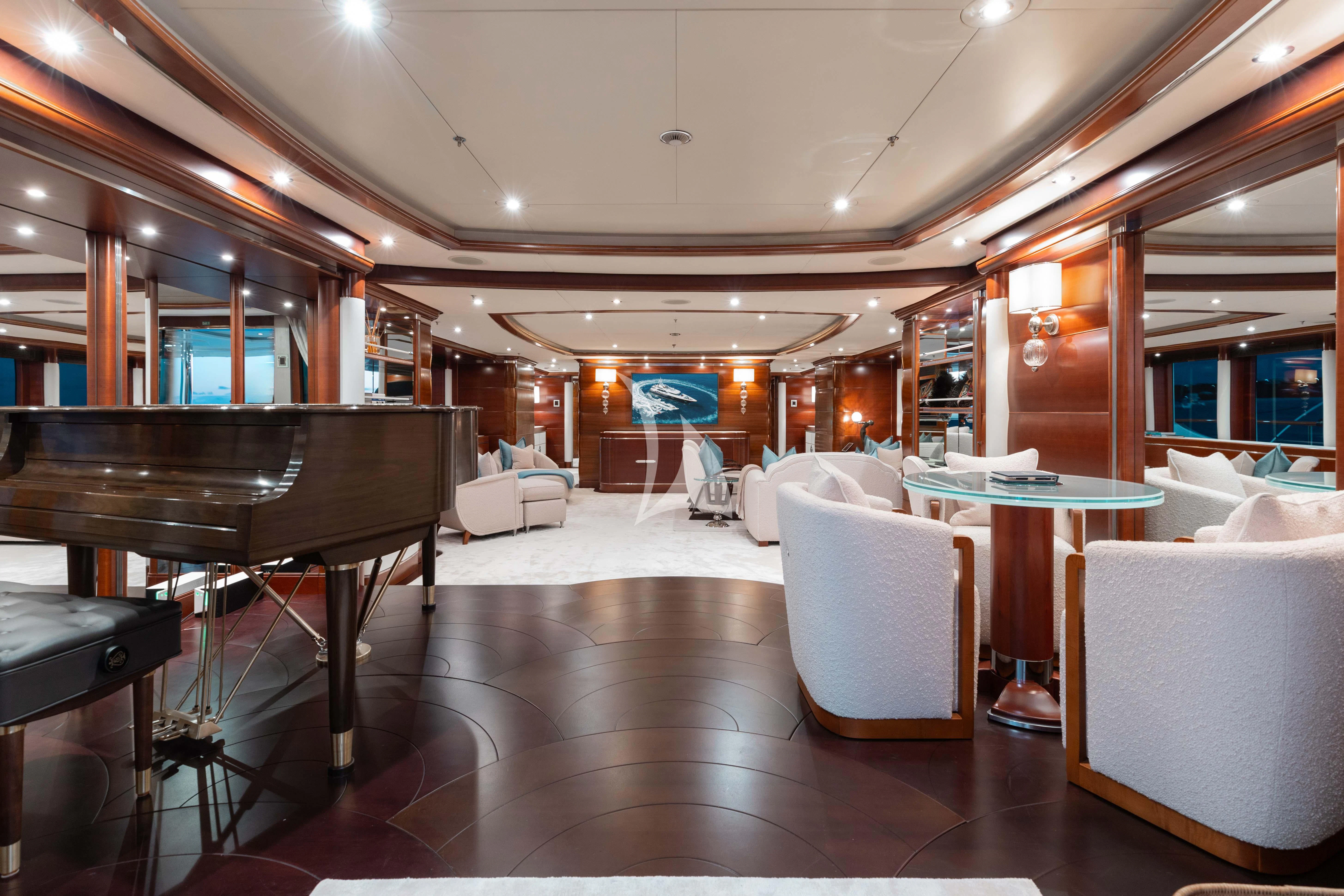 a room with a piano and chairs aboard LADY B Yacht for Charter