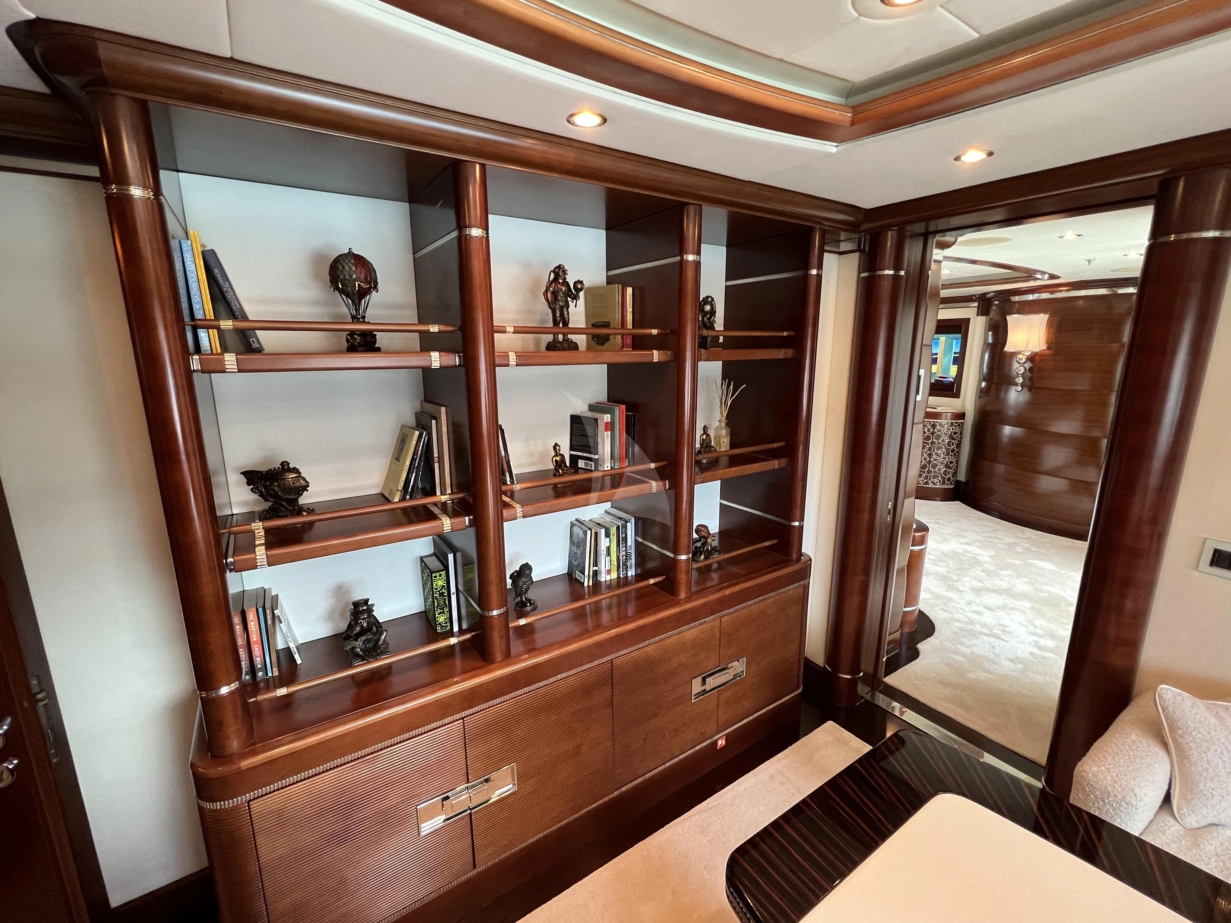a room with a book shelf and a mirror aboard LADY B Yacht for Charter