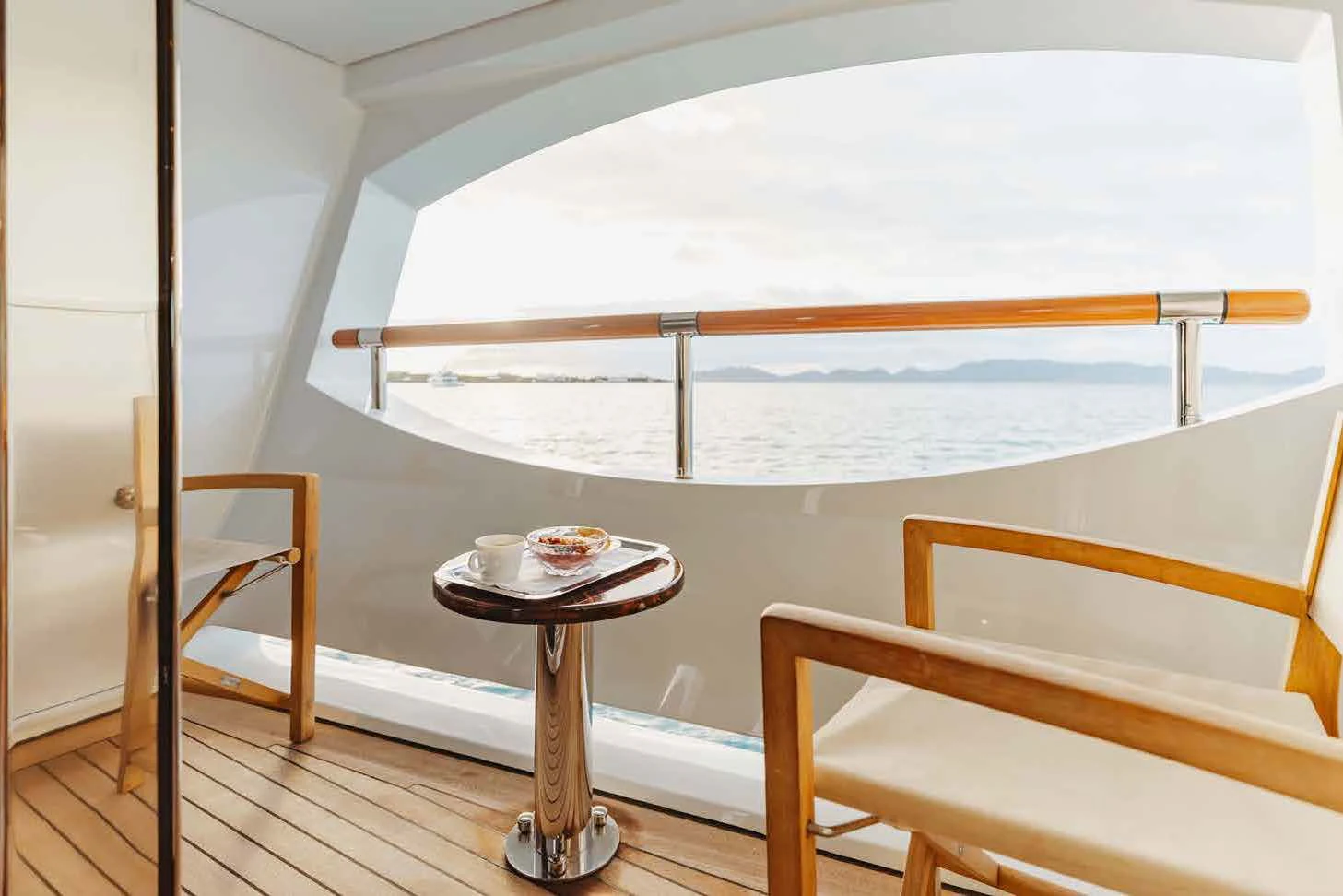 a table and a chair in a room with a large window aboard LADY B Yacht for Charter