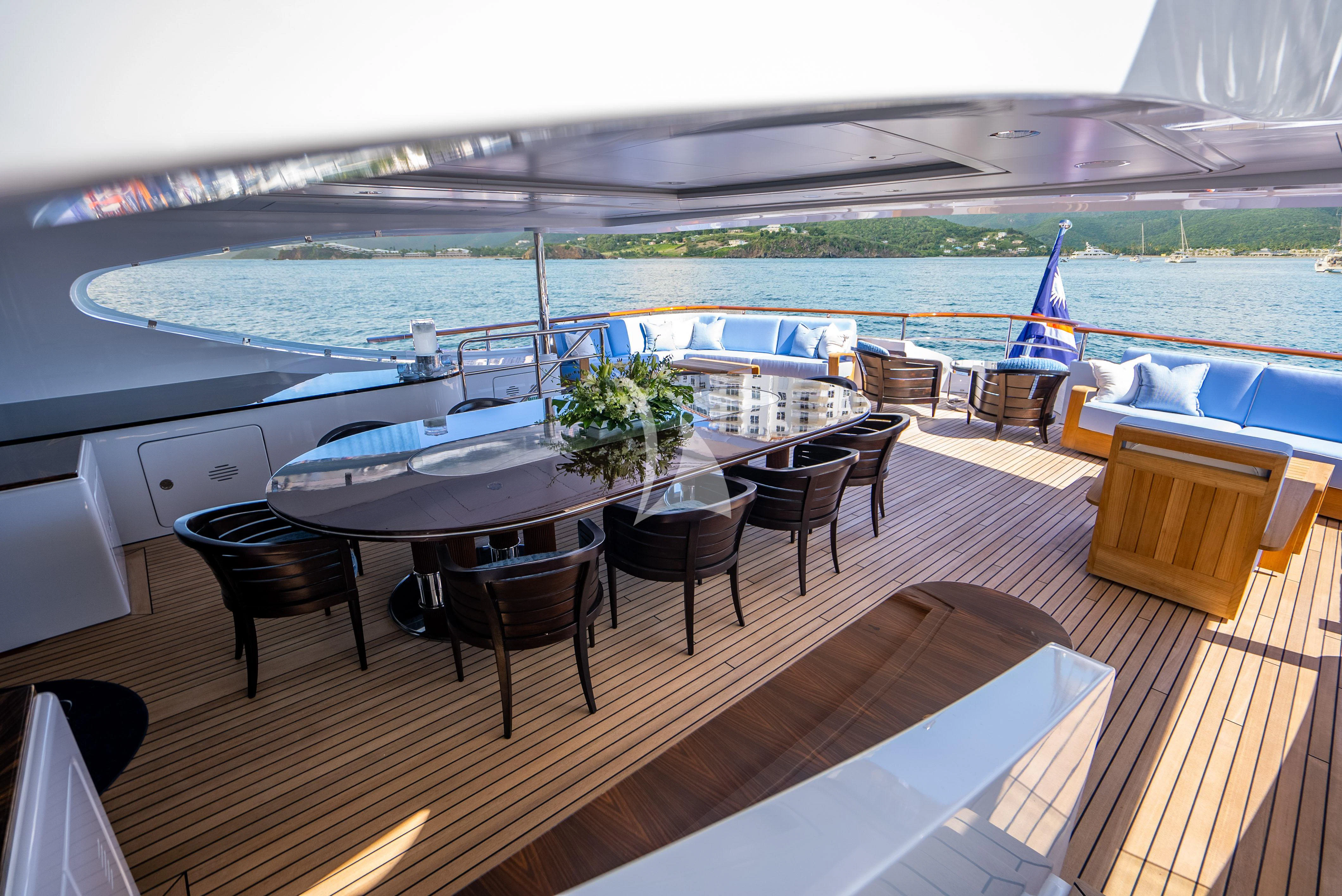 a deck with a table and chairs on it aboard LADY B Yacht for Charter