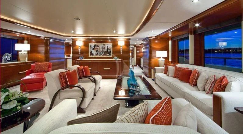 a living room with a large white couch and a large mirror aboard LADY B Yacht for Charter