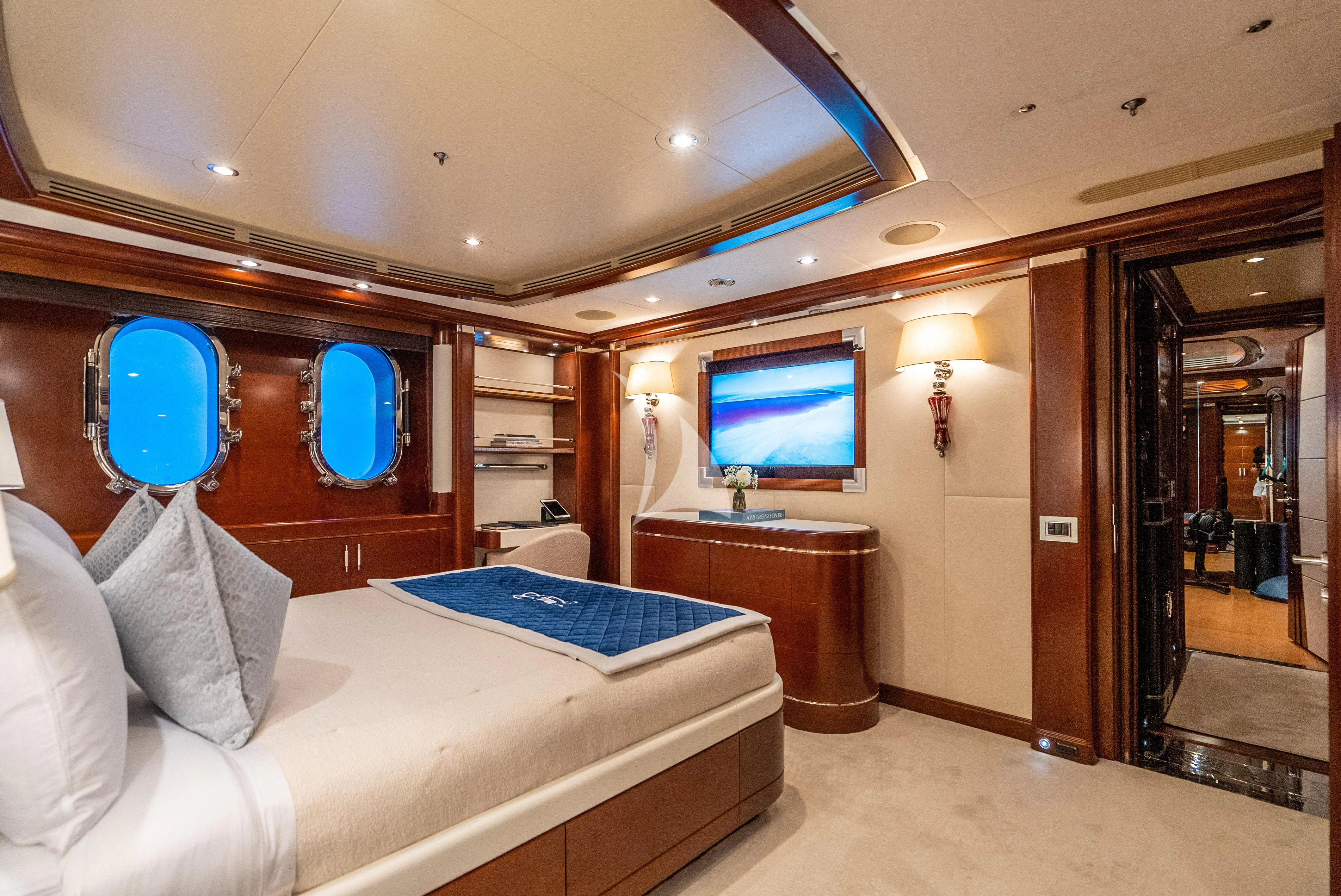 a room with a bed and a tv on the wall aboard LADY B Yacht for Charter