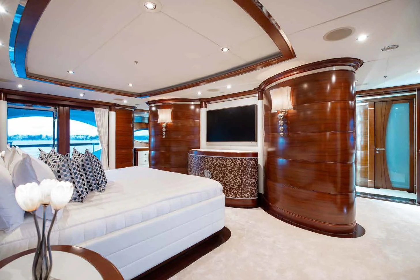 a room with a bed and a television aboard LADY B Yacht for Charter