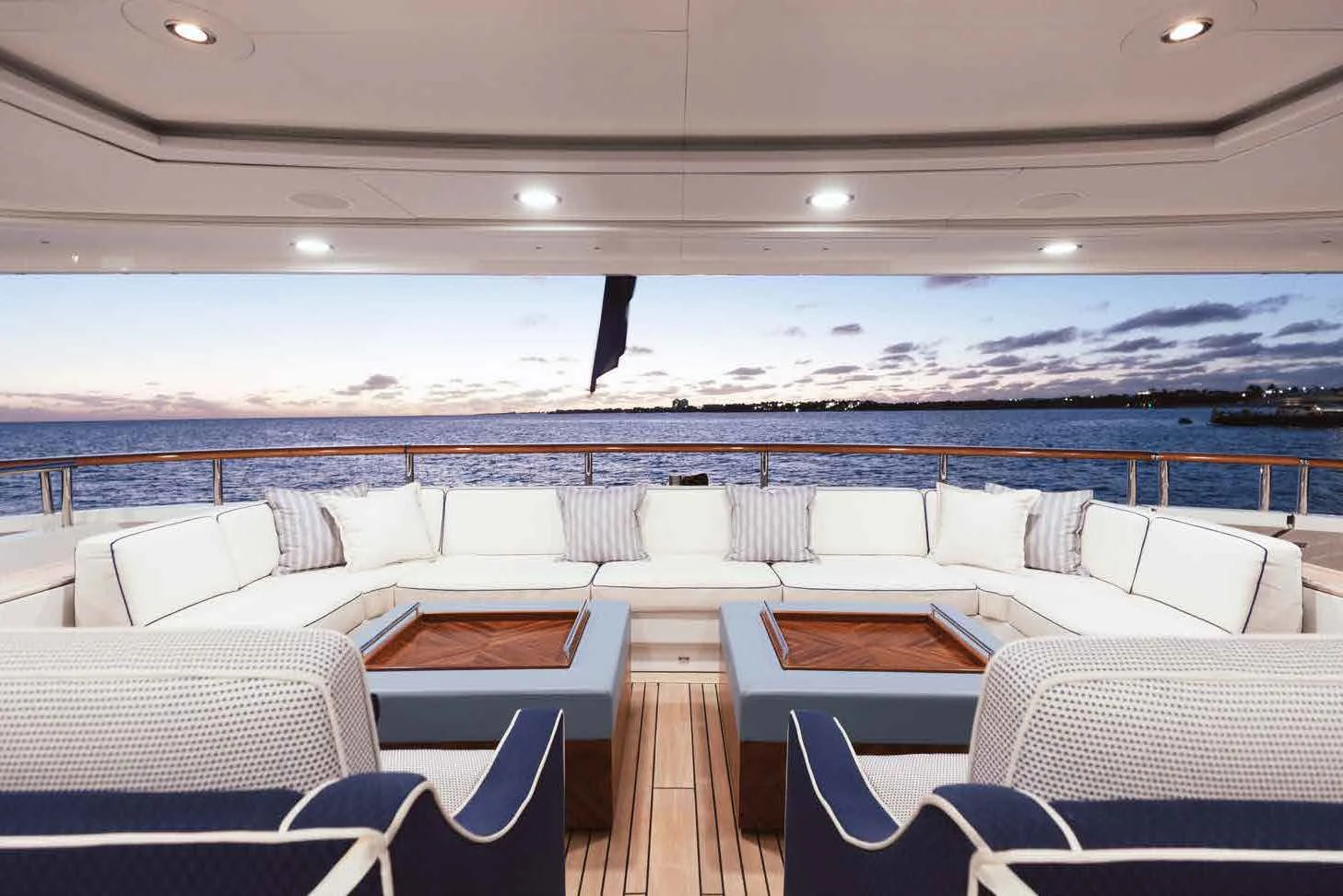 a room with chairs and a large body of water in the background aboard LADY B Yacht for Charter