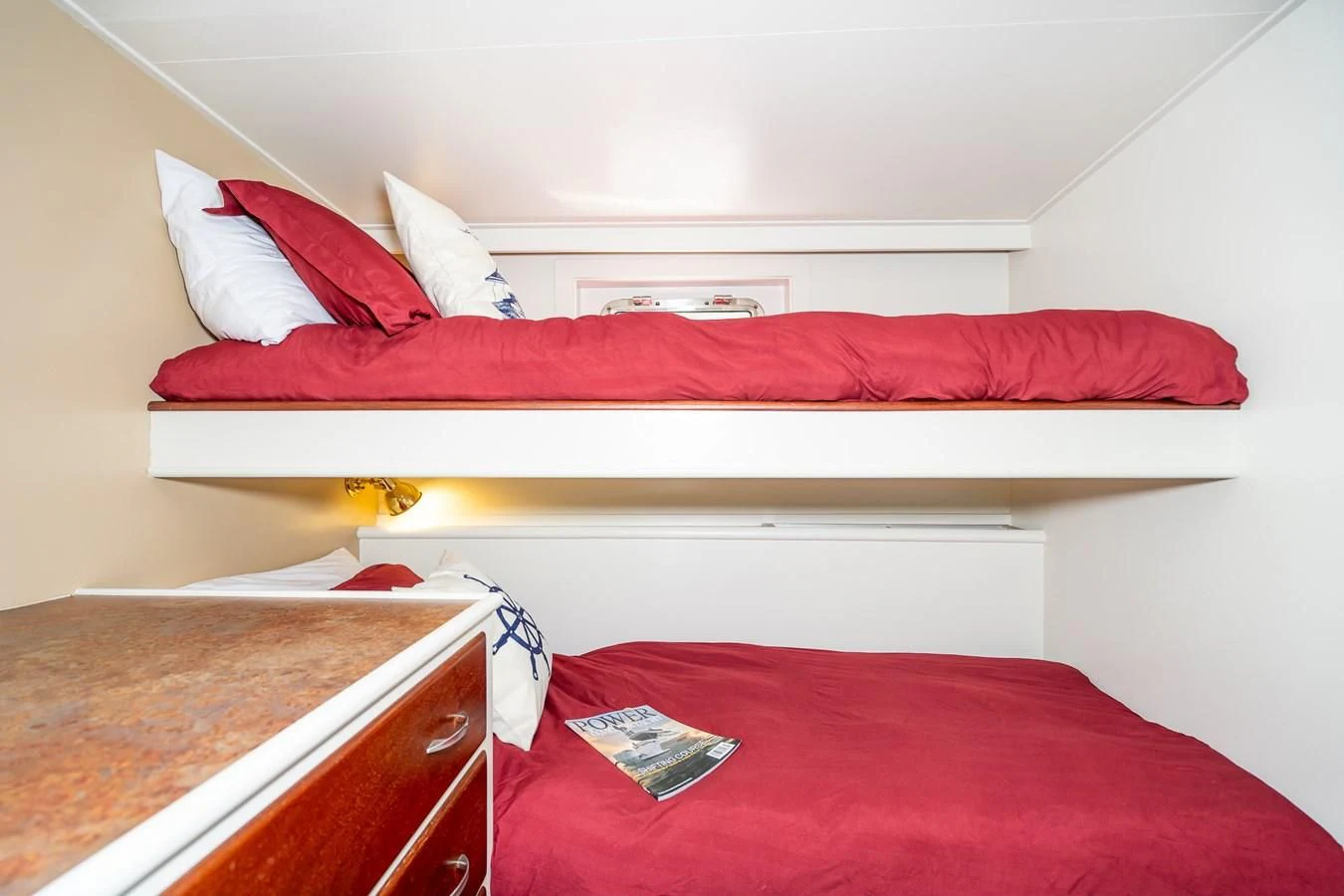 a bed with red sheets aboard SEA STAR Yacht for Sale