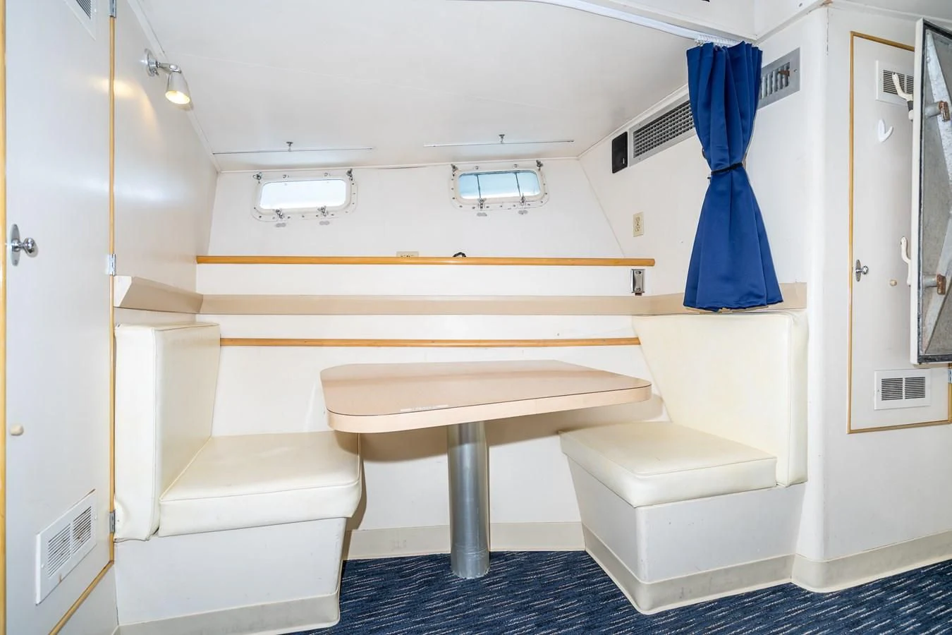 a white room with a white couch and a blue towel from the ceiling aboard SEA STAR Yacht for Sale