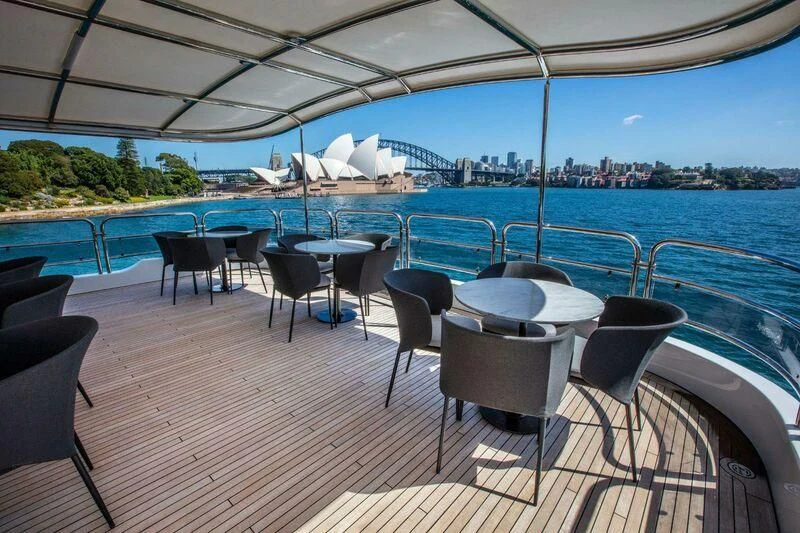 a group of tables and chairs on a deck by a pool aboard THE STAR Yacht for Sale