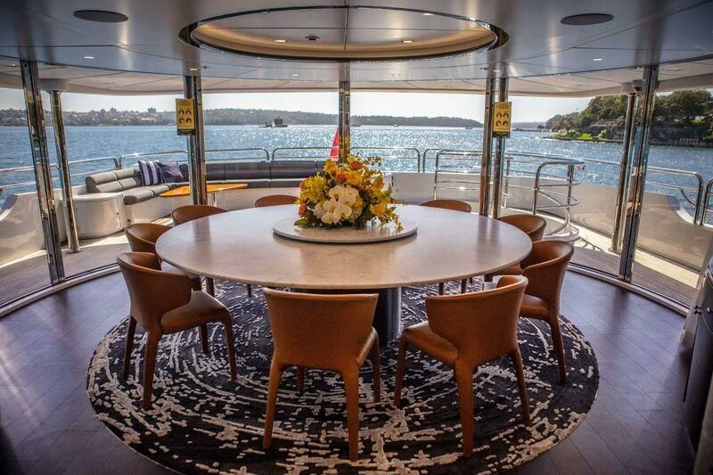 a table with chairs around it aboard THE STAR Yacht for Sale