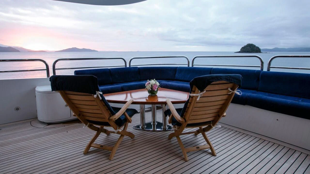 a couple of chairs on a deck overlooking a body of water aboard THE STAR Yacht for Sale