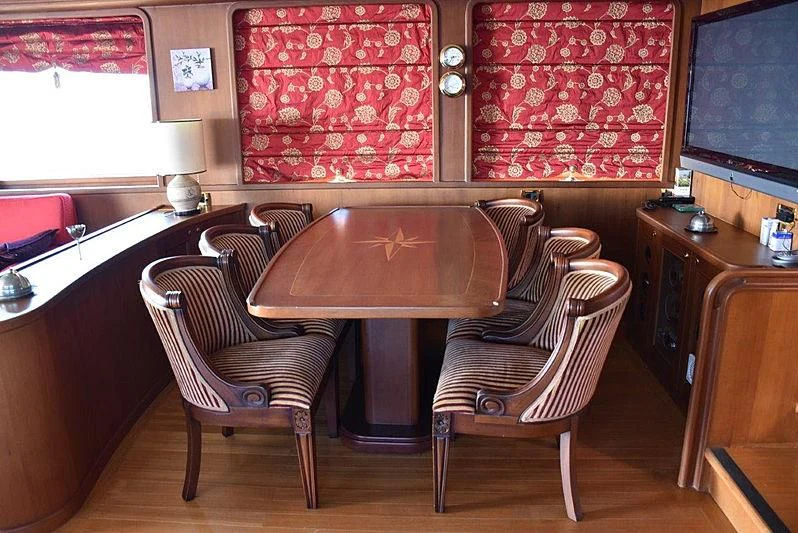 a table and chairs in a room aboard KUYIS Yacht for Sale