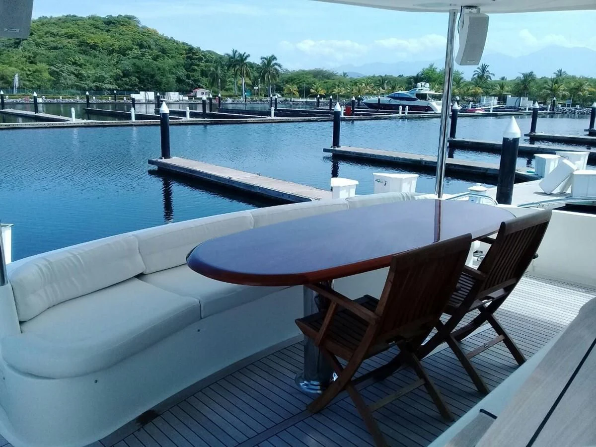a deck with chairs and a table on it aboard LAZZARA 68' Yacht for Sale