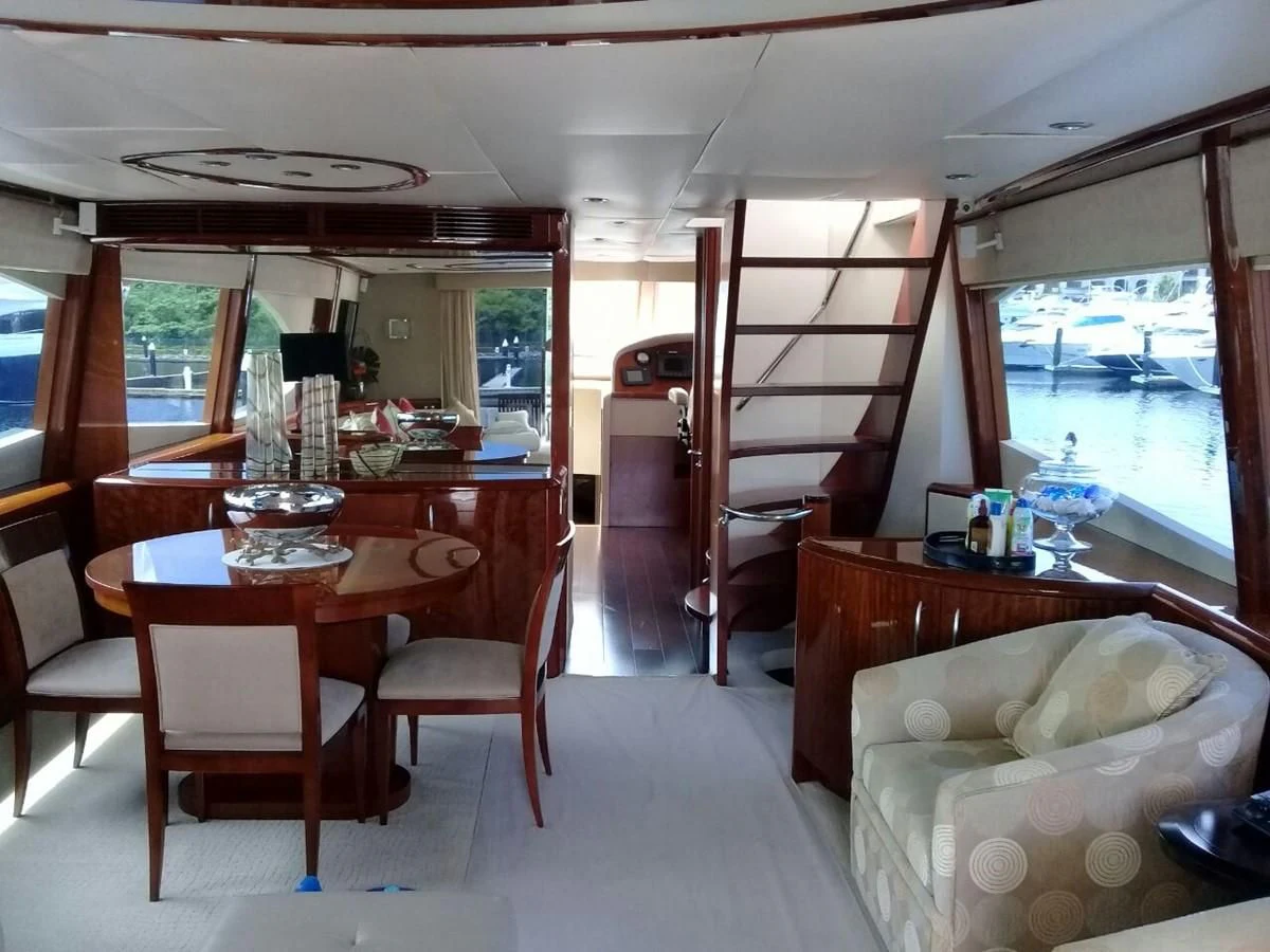 a room with a table and chairs aboard LAZZARA 68' Yacht for Sale
