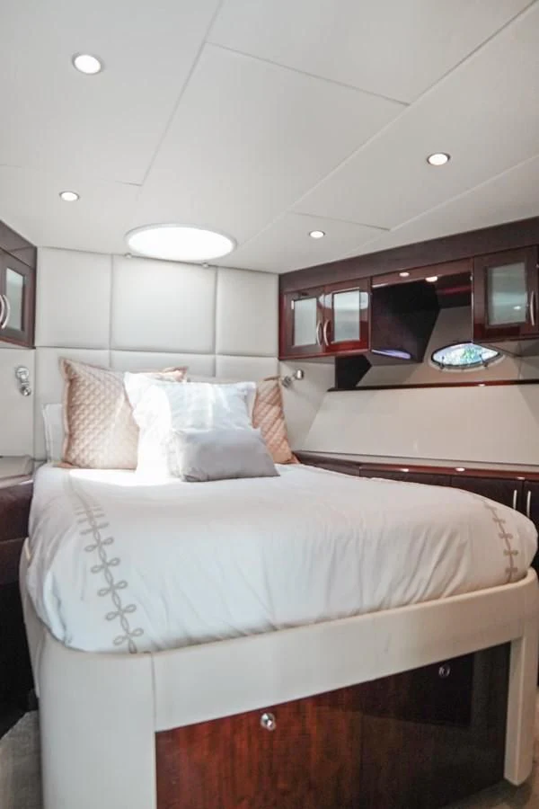 a room with a bed and a television aboard LAZZARA 68' Yacht for Sale