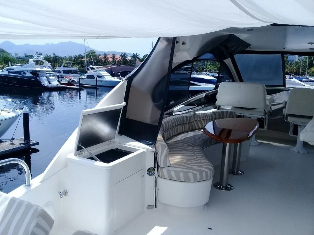 a boat with a chair and a table on it aboard LAZZARA 68' Yacht for Sale