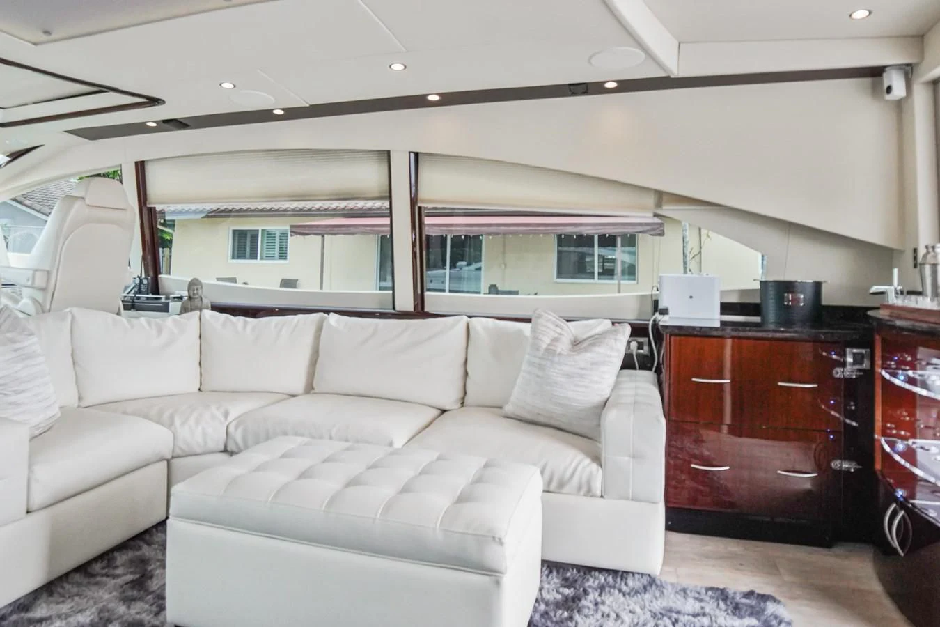 a living room with a couch and a window aboard LAZZARA 68' Yacht for Sale