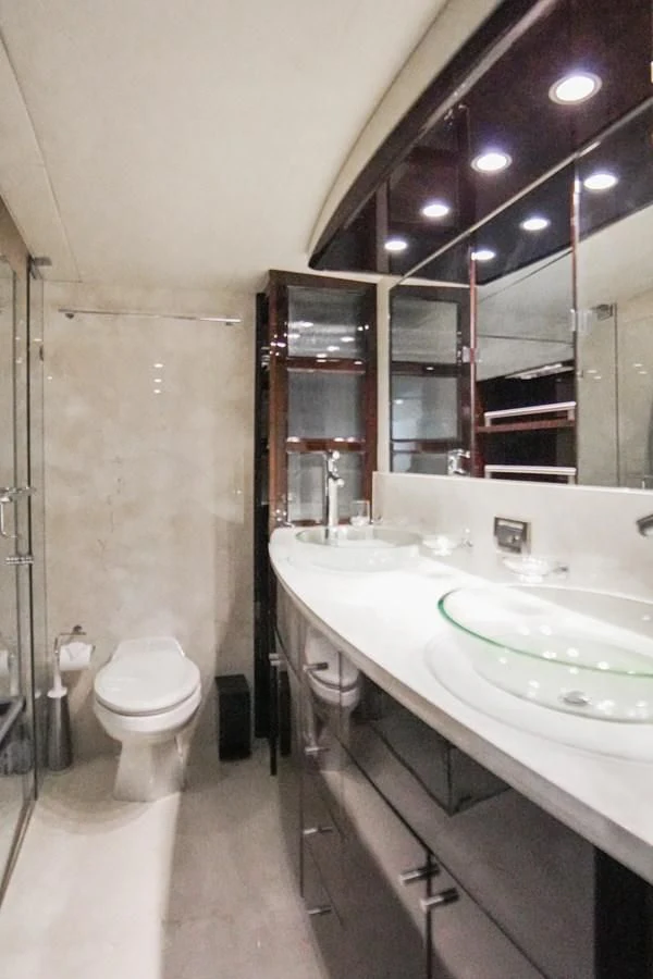 a bathroom with a sink toilet and a mirror aboard LAZZARA 68' Yacht for Sale