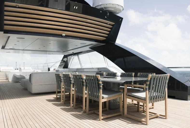 a deck with a table and chairs on it aboard ENTOURAGE Yacht for Sale
