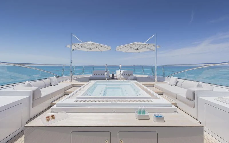 a large white pool with a deck and a large white building on the side aboard ENTOURAGE Yacht for Sale