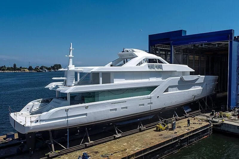 a white yacht docked at a dock aboard ENTOURAGE Yacht for Sale