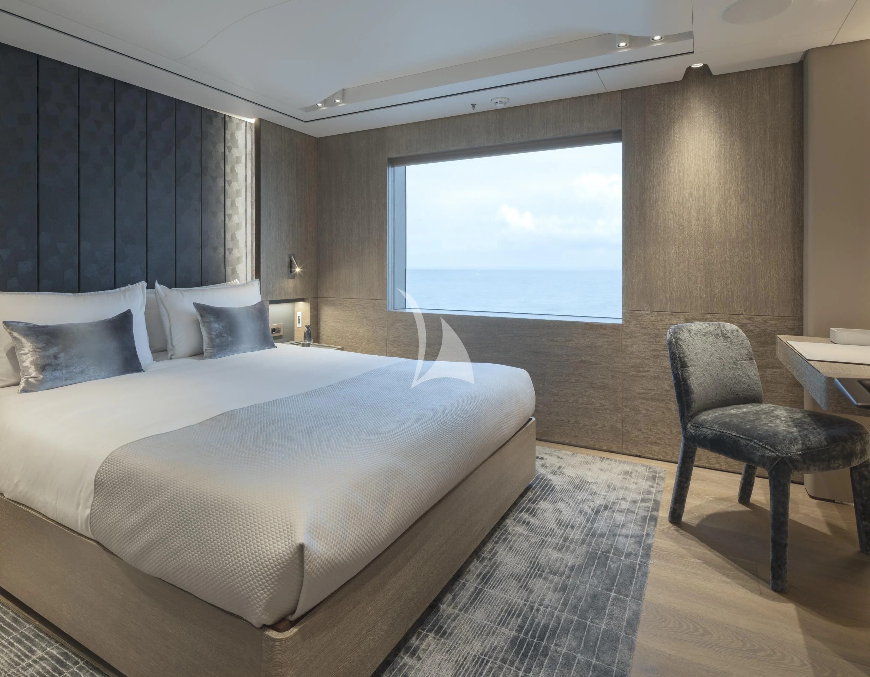 a bedroom with a bed and a chair aboard ENTOURAGE Yacht for Sale