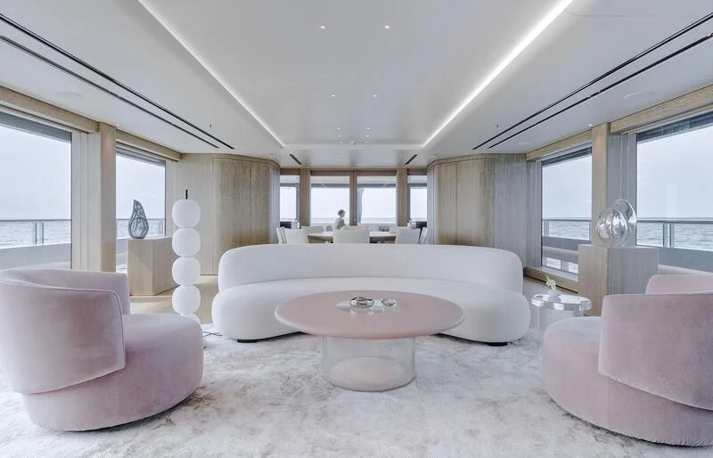 a large living room with a large white sofa and a large white table aboard ENTOURAGE Yacht for Sale