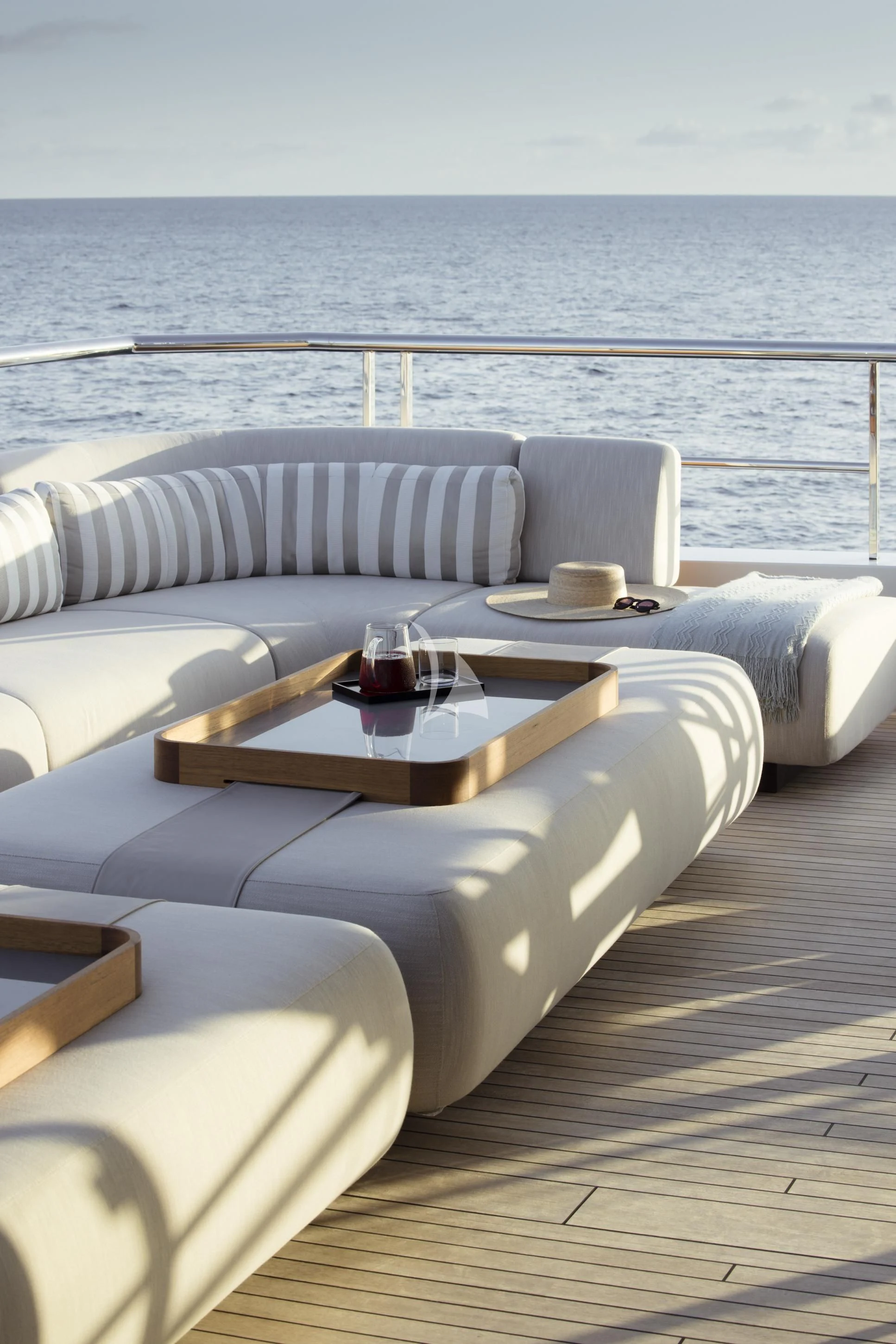 a couch and a table on a deck overlooking the ocean aboard ENTOURAGE Yacht for Sale