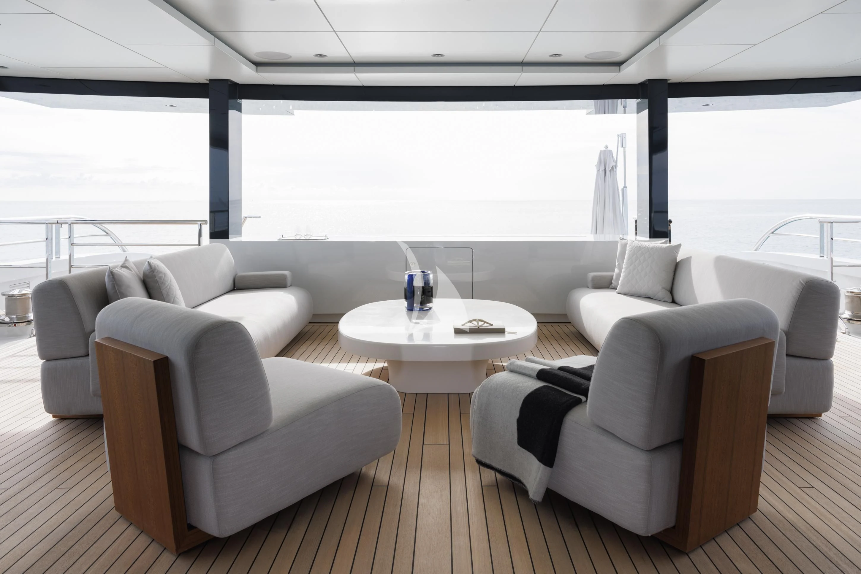 a room with white chairs and a table with a glass on it aboard ENTOURAGE Yacht for Sale