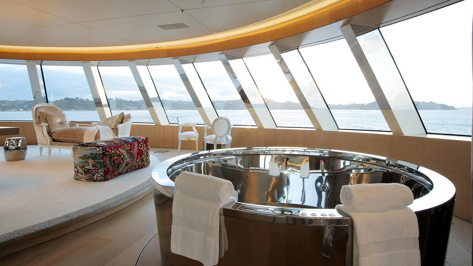 a dining table with chairs and a large window overlooking the ocean aboard A Yacht for Sale