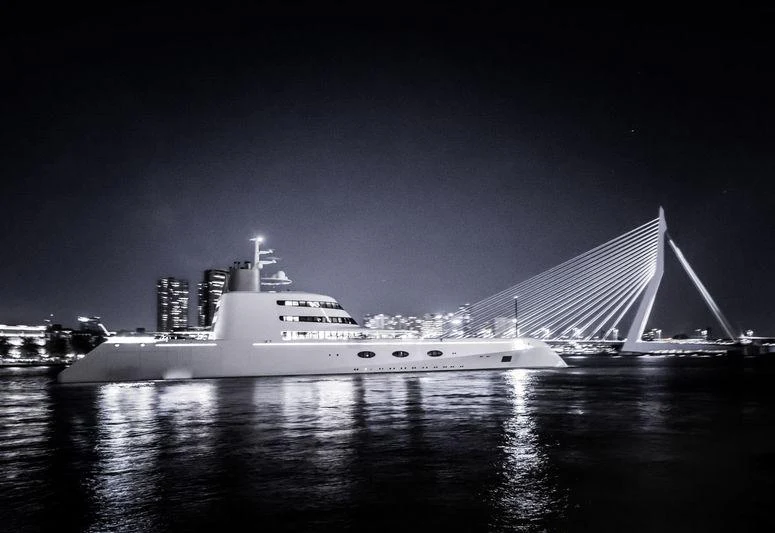 a large white boat in front of a large building aboard A Yacht for Sale