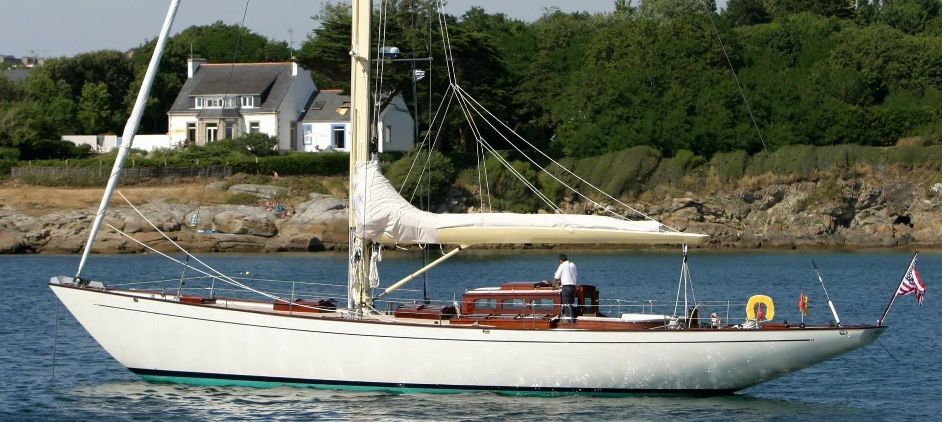 a white boat with a sail on the water aboard ALDEBARAN Yacht for Sale