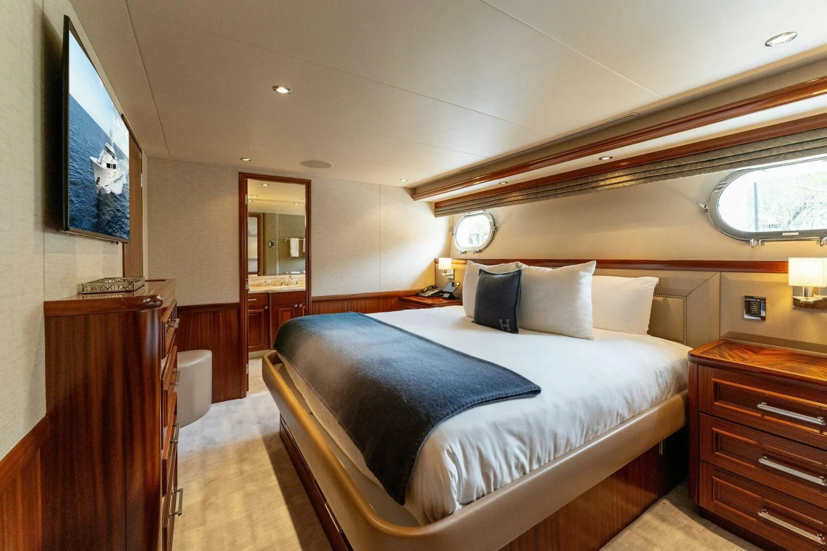 a bedroom with a bed and a television on the wall aboard ANTARES Yacht for Sale