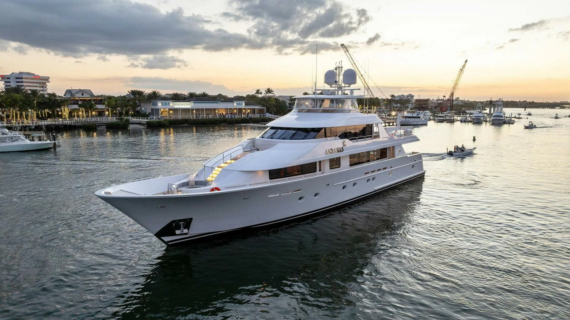 a large white boat in a harbor aboard ANTARES Yacht for Sale