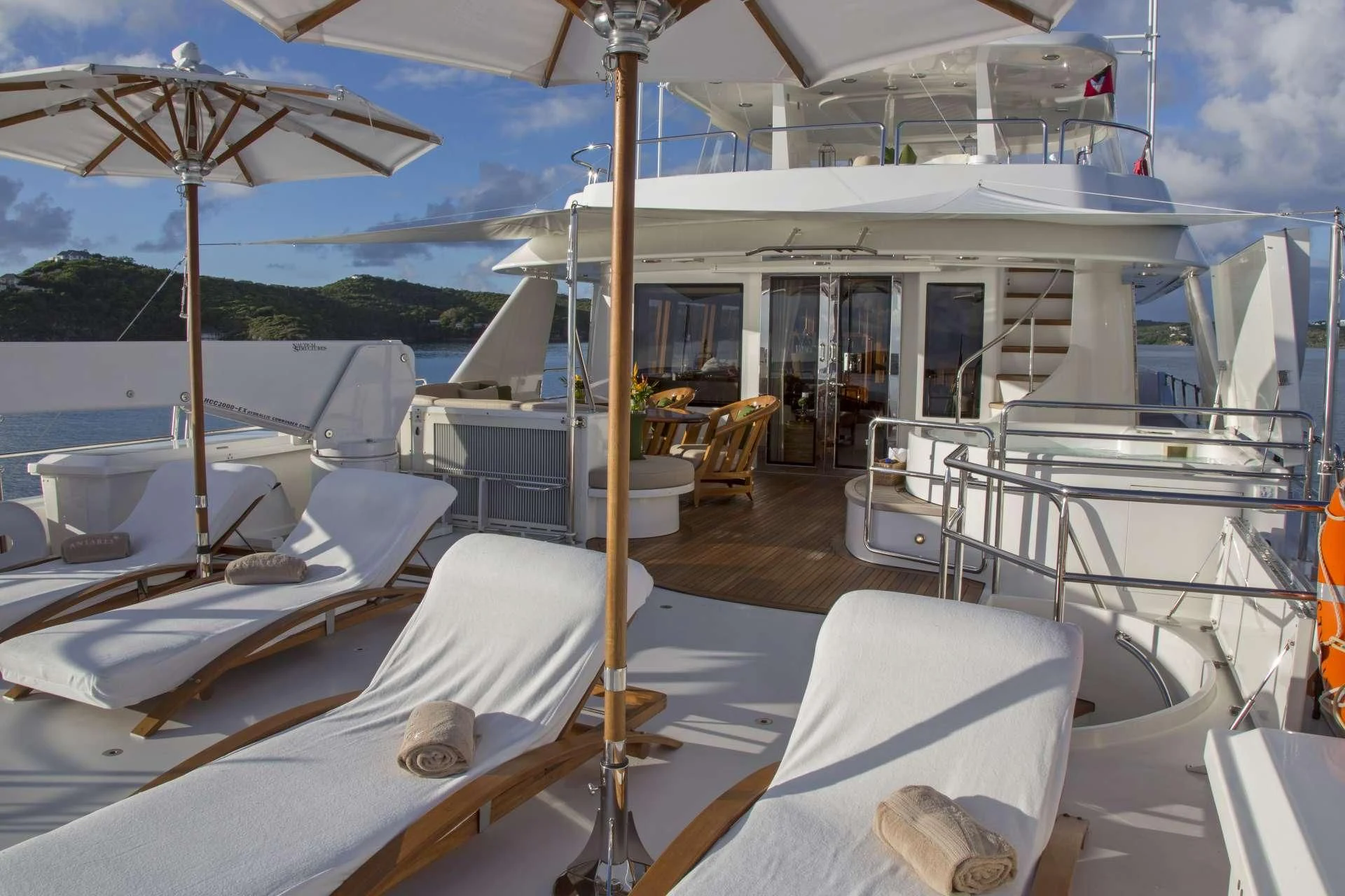 a boat with white beds and umbrellas on a deck aboard ANTARES Yacht for Sale