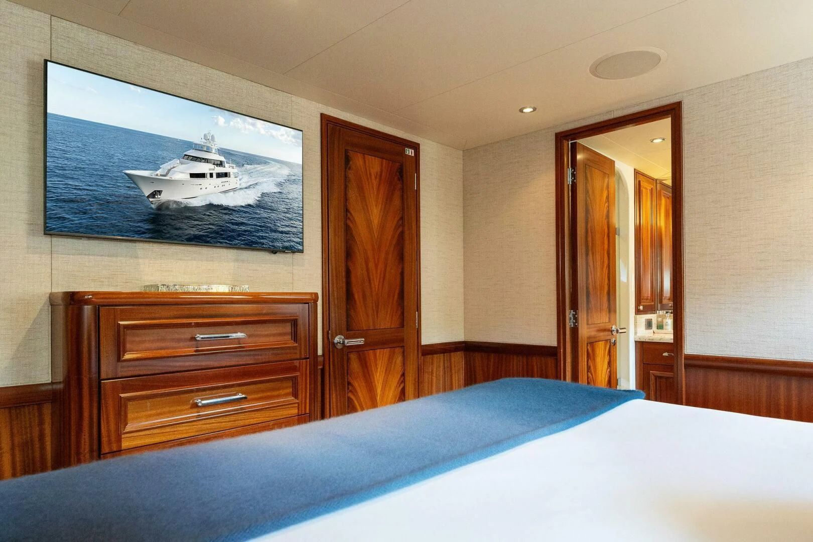 a bedroom with a bed and a television on the wall aboard ANTARES Yacht for Sale