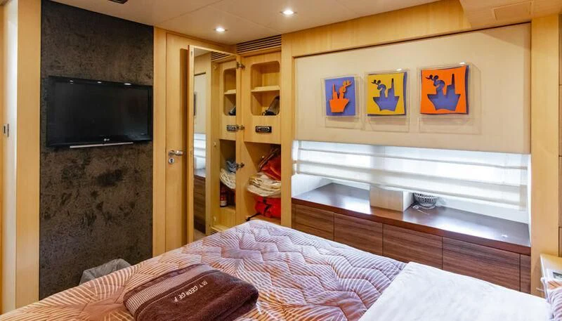 a bedroom with a bed and tv aboard EL DISPARO Yacht for Sale