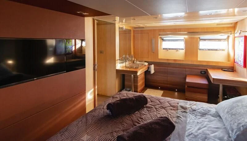 a bedroom with a bed and a desk aboard EL DISPARO Yacht for Sale
