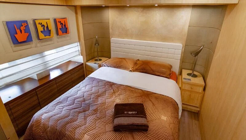 a bed with a pillow and a book on it aboard EL DISPARO Yacht for Sale