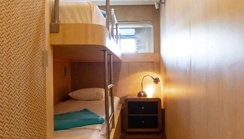 a room with a bed and a lamp aboard EL DISPARO Yacht for Sale