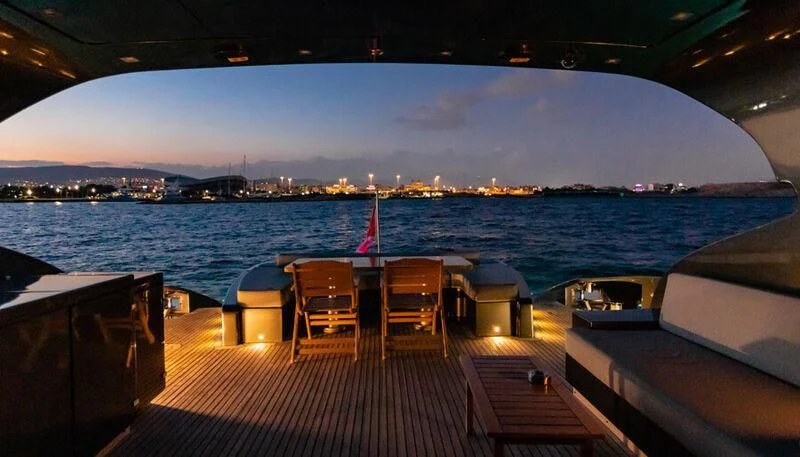 a deck with chairs and a body of water in the background aboard EL DISPARO Yacht for Sale